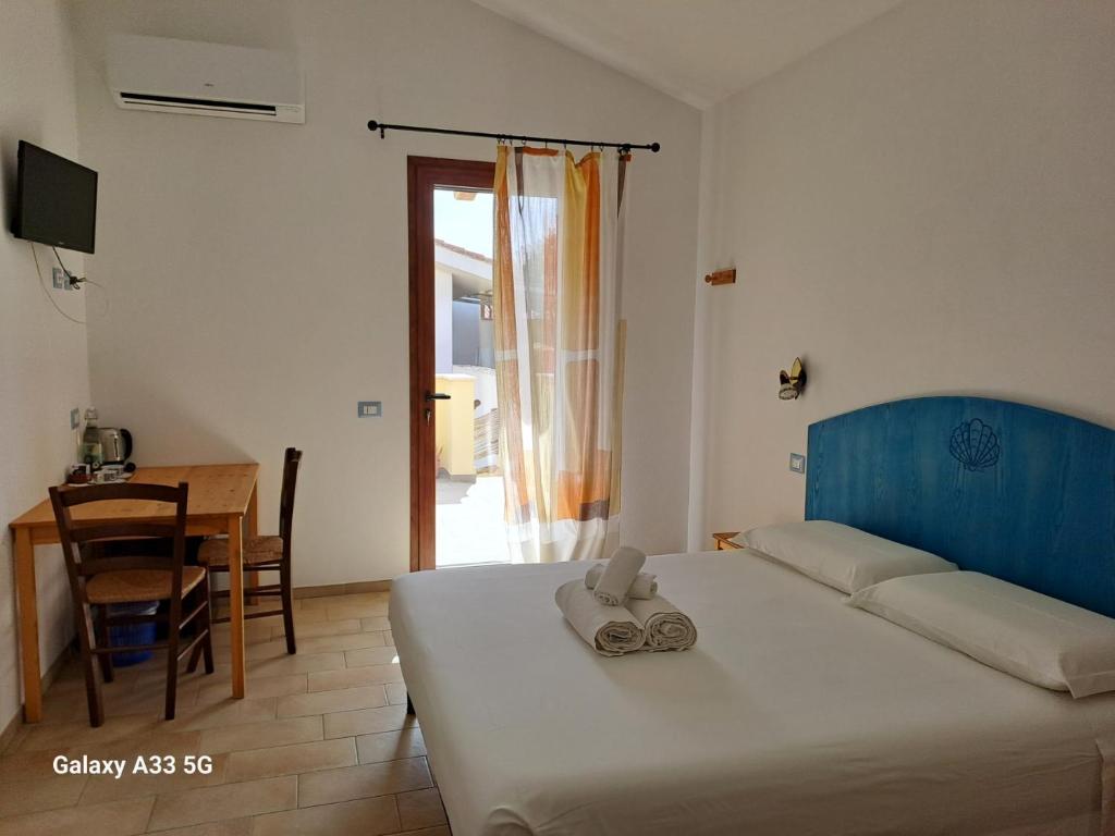 a bedroom with a bed and a table and a dining room at Sa Cannizzada in Funtana Meiga