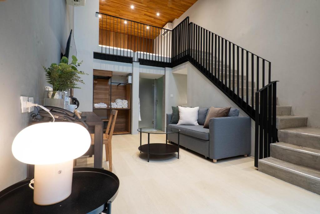 a living room with a staircase and a couch at Woodstory Boutique Hotel in Bangkok