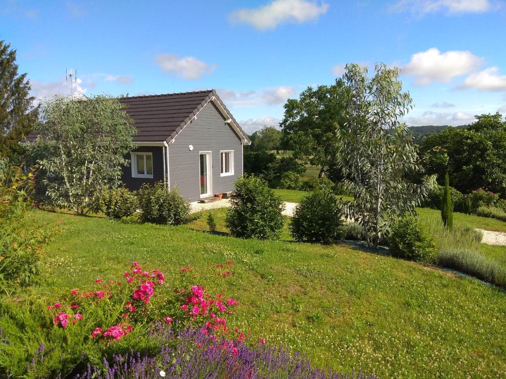 a small house in a field with flowers at Noa gris in Saint-Martin-sur-Ocre