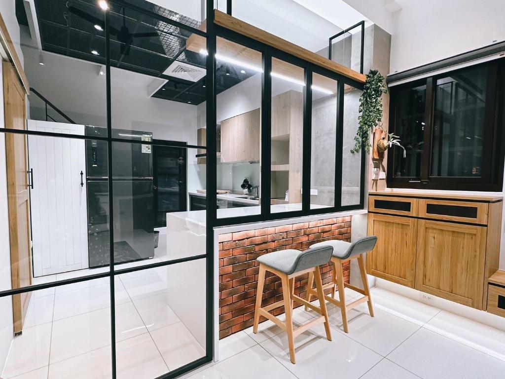 a kitchen with glass walls and a table and a stool at N 24.8宜蘭頭城包棟民宿 in Toucheng