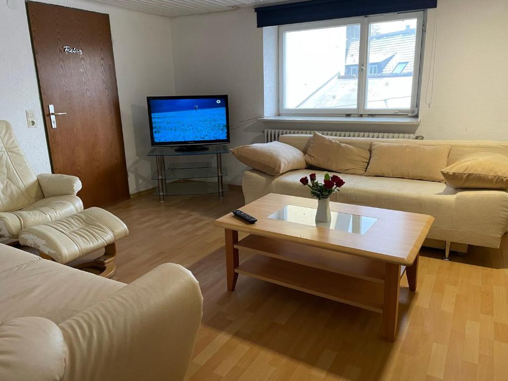 een woonkamer met banken en een tafel en een televisie bij Wohnung Apartments Beny in Bad Bellingen