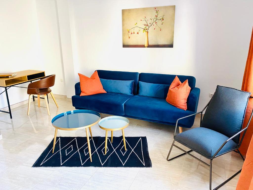 ein blaues Sofa und zwei Stühle im Wohnzimmer in der Unterkunft Haus LIDZBARSKI in Burriana