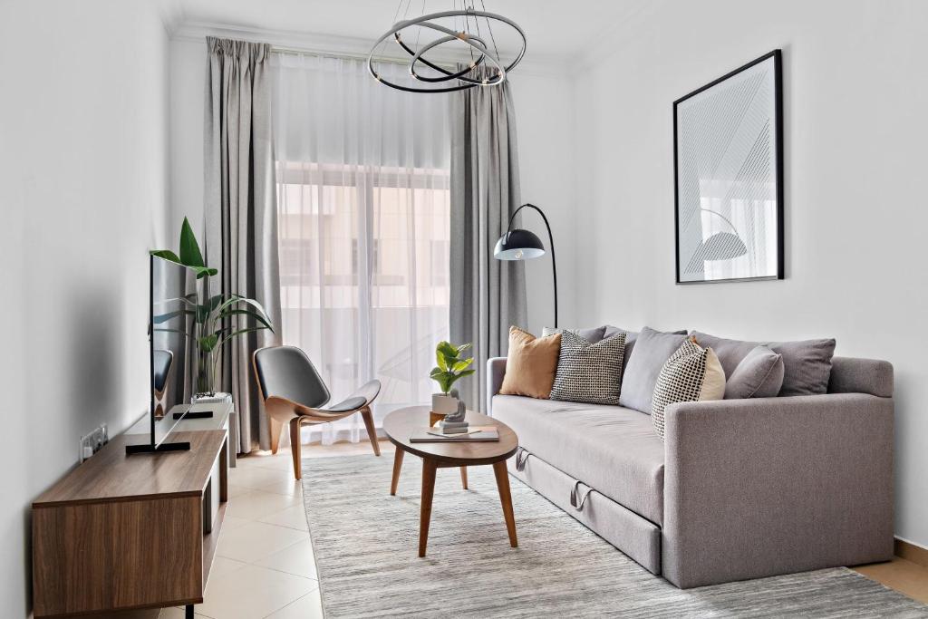 a living room with a couch and a table at Silkhaus Luxury 1 BDR with Metro Nearby in Dubai