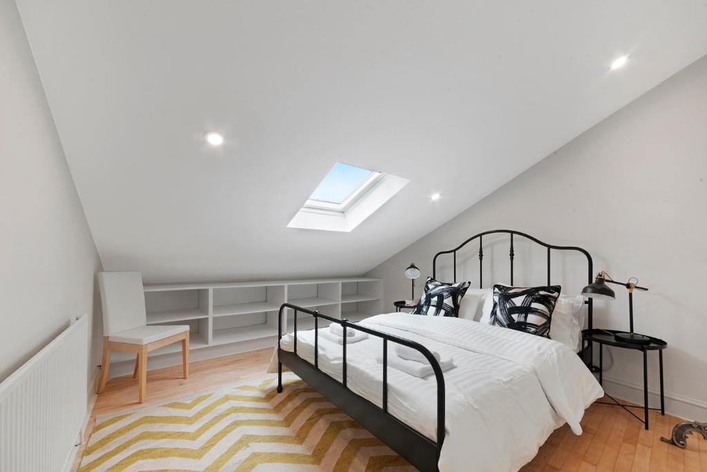 a bedroom with a bed and a skylight at Former Victorian Bakery Conversion in the Heart of Highbury in London