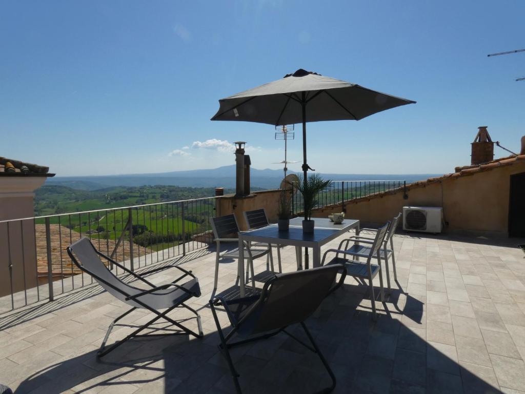 a patio with a table and chairs and an umbrella at Scappo in Umbria, La Terrazza in Lugnano in Teverina