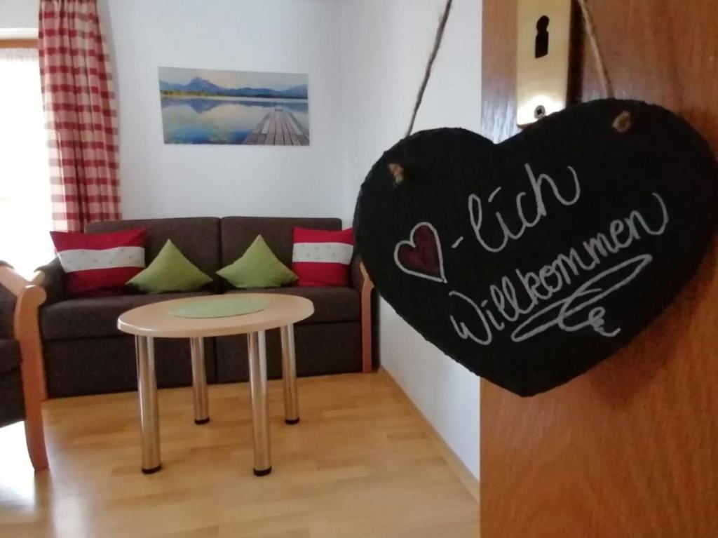 a living room with a heart shaped couch and a table at Ferienhof Hefele Ferienwohnung Hopfensee mit KönigsCard in Hopferau