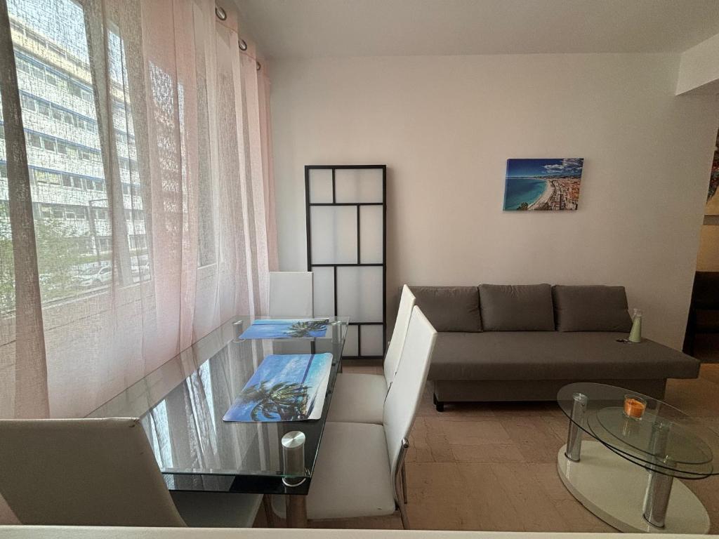 sala de estar con sofá y mesa de cristal en Grand studio de 30 m2 Promenade des Anglais en Niza