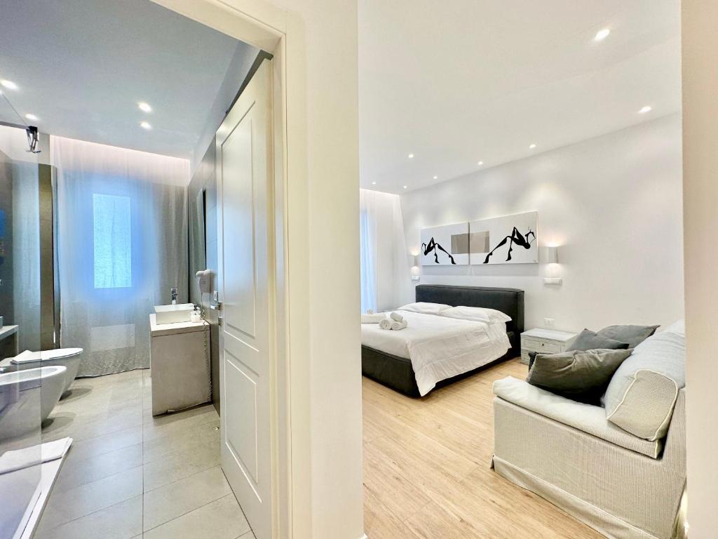a white bedroom with a bed and a couch at CeO LUXURY SUITE DI CAGLIARI in Cagliari