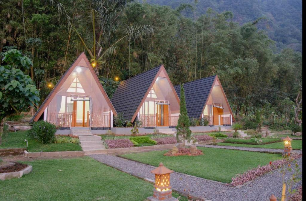 un ensemble de trois cottages dans un jardin dans l'établissement Popitan Garden Campground & Glamping Bedugul, à Bedugul