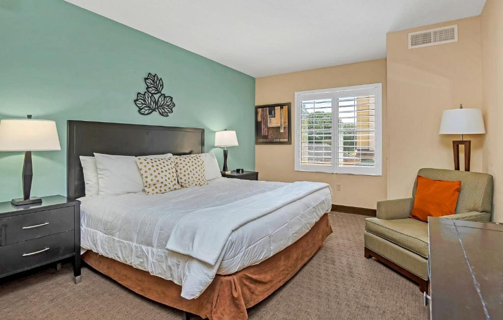 1 dormitorio con 1 cama grande y 1 silla en 1BR Exec Suite-King Bed -Pool-Hot Tub-Near Disney, en Orlando