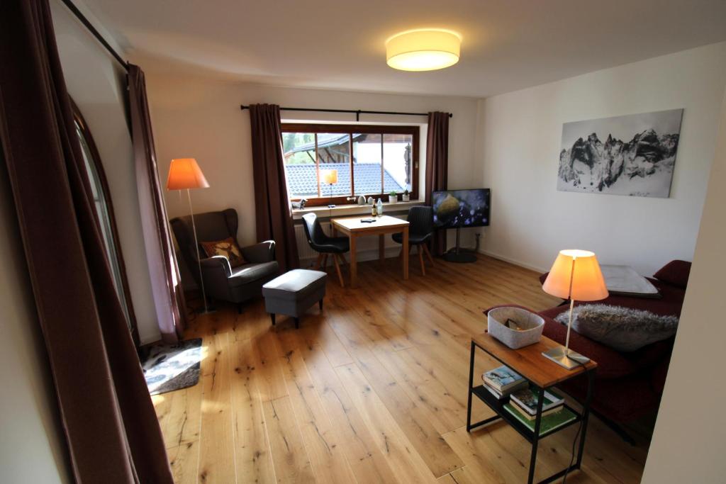 uma sala de estar com um sofá e uma sala de jantar em Isarkindl em Krün
