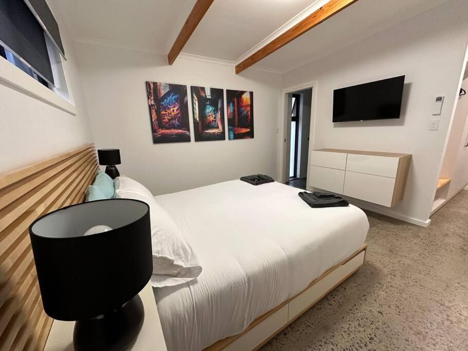 een slaapkamer met een groot bed en een tv aan de muur bij The Hilltop, spacious family retreat with views! in Port Lincoln