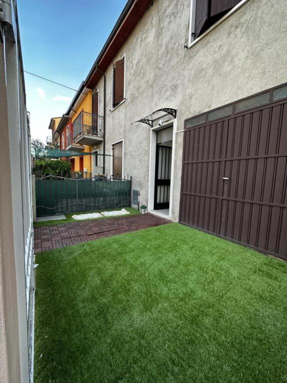 a yard of a house with a brown garage at Civico 56 in Verona