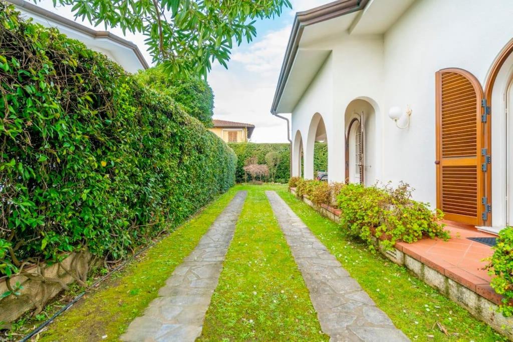 een tuinpad dat leidt naar een wit huis bij Villa Olivia in Forte dei Marmi