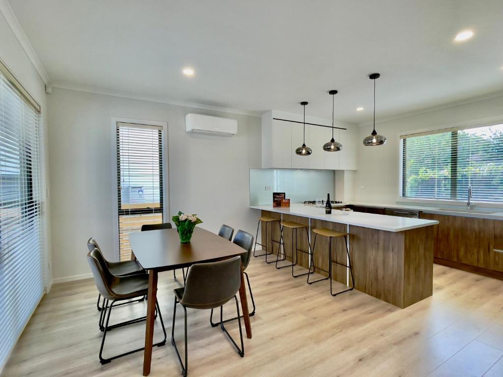 uma cozinha com mesa e cadeiras e um balcão em Glendowie Brand-new comfortable 3 & 4-bedroom Houses em Auckland