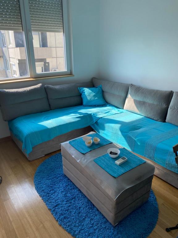 sala de estar con sofá azul y alfombra azul en Love birds place, en Skopje