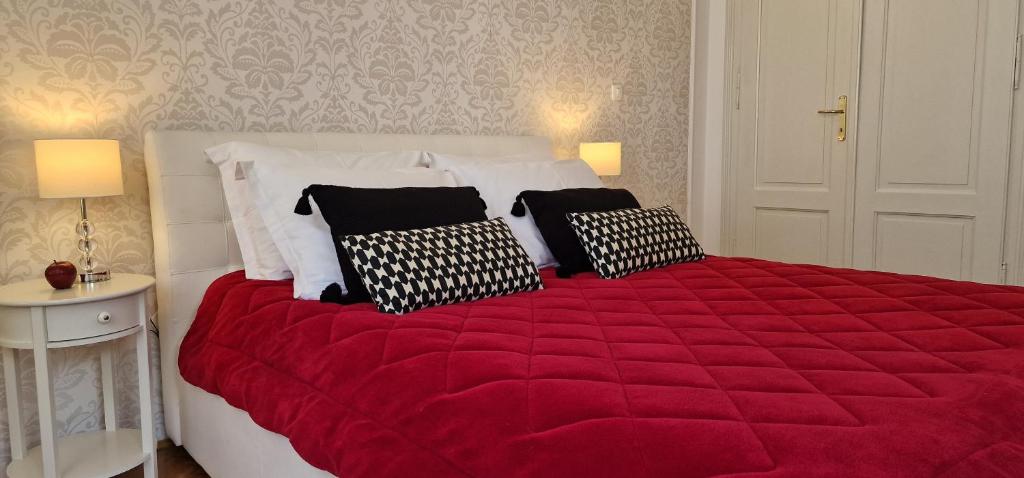 a bedroom with a large red bed with four pillows at Apartment Medea 2 with private parking in Opatija