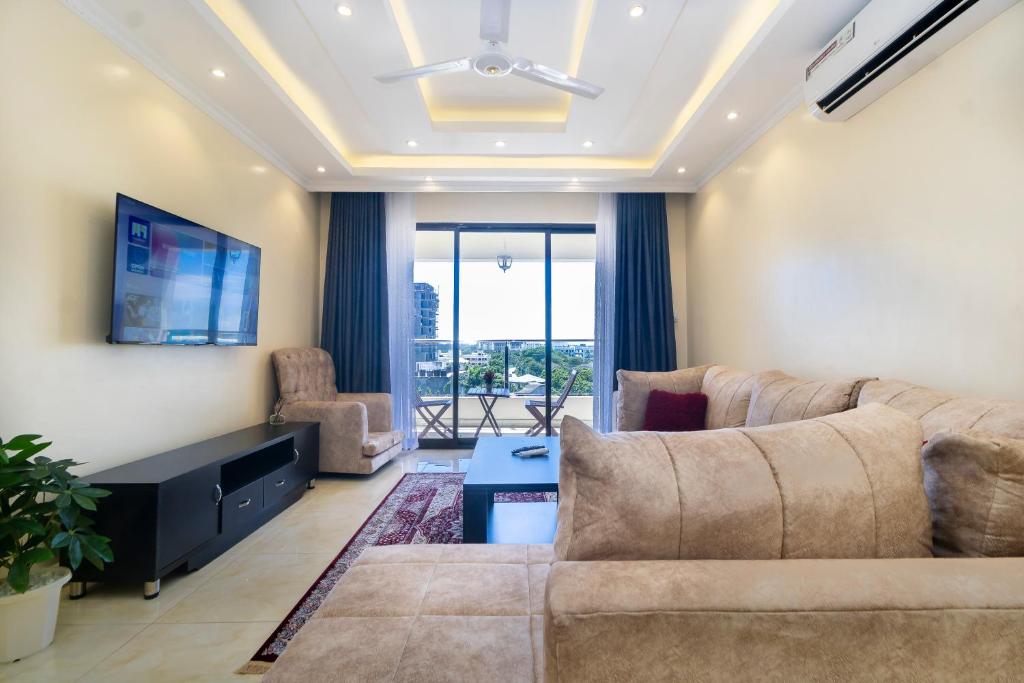 a living room with a couch and a tv at Mombasa Nyali Beachfront Apt in Mombasa