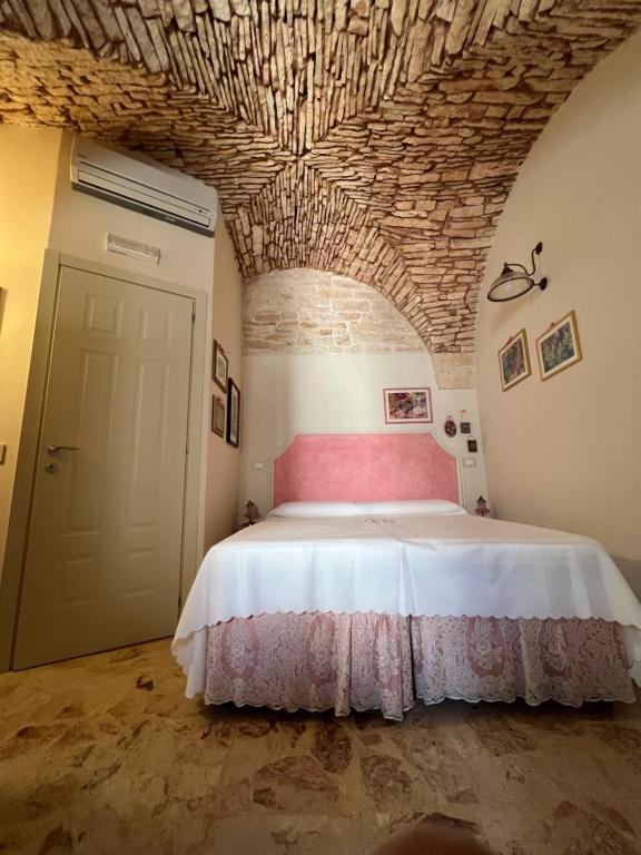 een slaapkamer met een groot bed en een bakstenen plafond bij B&B A Casa di Marilù in Martina Franca