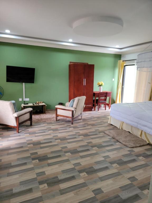 a bedroom with a bed and a flat screen tv at Mew3 Apartment in Ndola