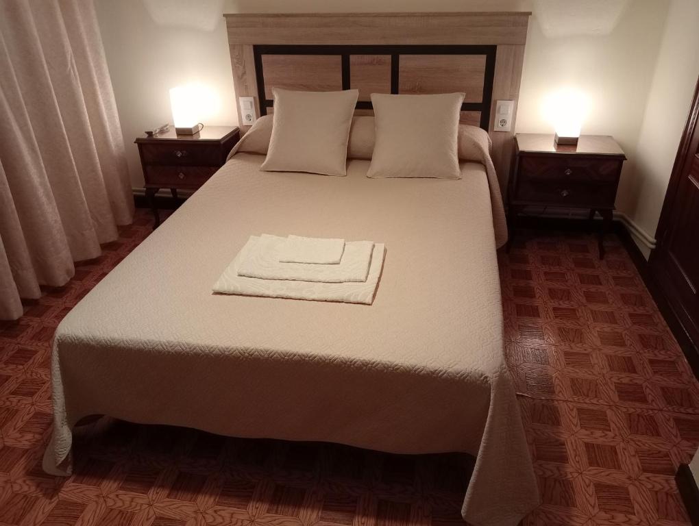 una camera da letto con un grande letto con due comodini di Habitacion matrimonial centro ciudad a Oviedo