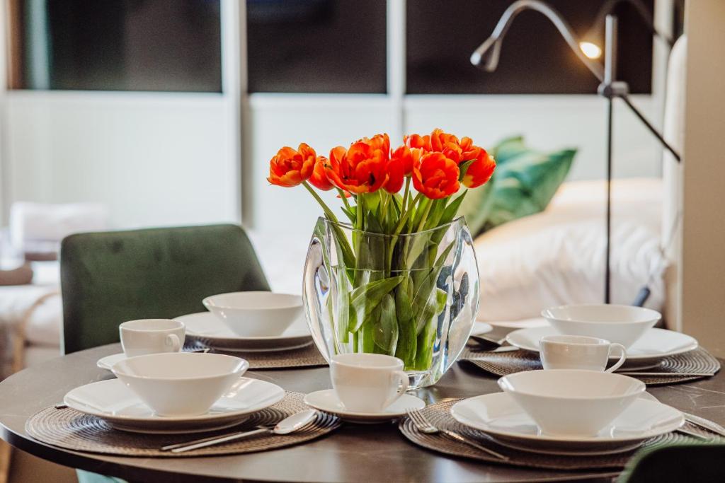 ein Tisch mit einer Vase mit roten Tulpen darauf in der Unterkunft 1 Maja 76 in Jelenia Góra