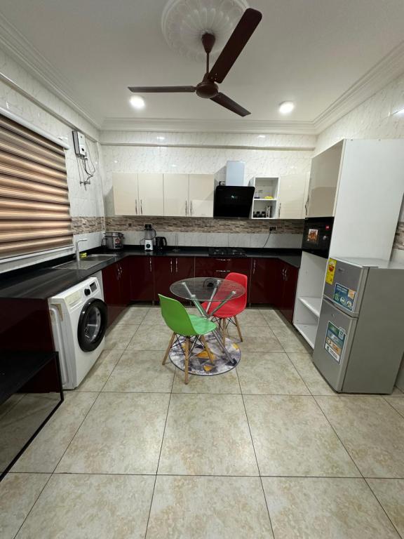 uma cozinha com uma mesa e duas cadeiras e um aparelho em Best Apartment em Adentan
