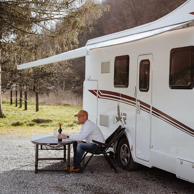 Un homme assis à une table à côté d'un rv dans l'établissement the green paradise, à Celles