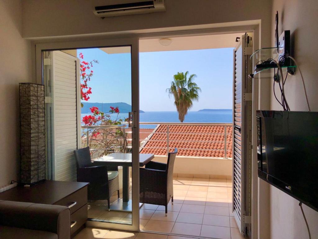 a living room with a table and a view of the ocean at Boka Residence 7 in Herceg-Novi