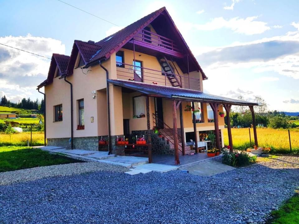 une grande maison avec un toit sur un champ dans l'établissement Casă de vacanță, à Topliţa