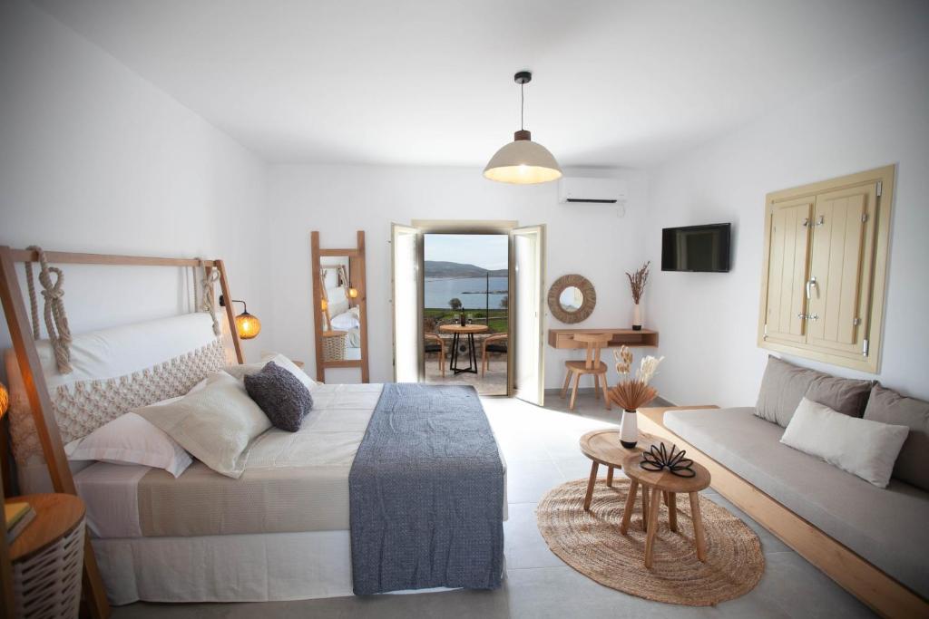 a bedroom with a bed and a living room with a couch at Agathia Resort in Schinoussa