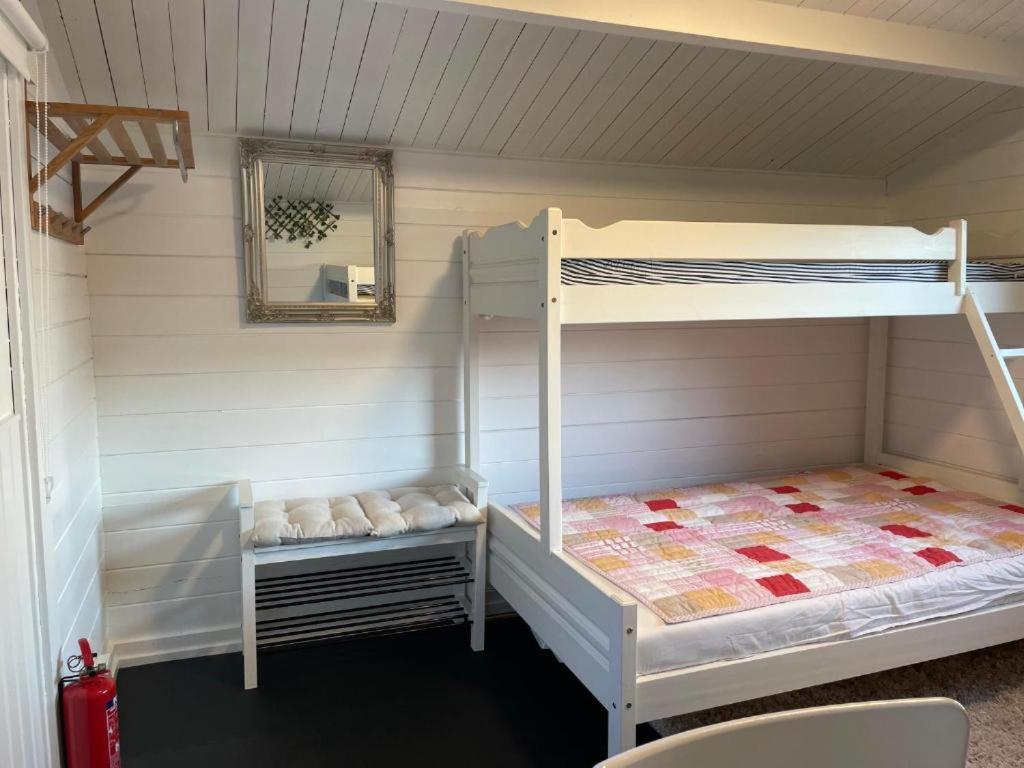 a room with two bunk beds and a mirror at Nice Apartment with1 bedroom Separate living room with a sofa bed and a tiny kitchen a bathroom located in Nordstrand near by the Sea for 3 guests with a garden and grill 5 extra guests with extra cost in the cabin with sea view just outside the apartment in Oslo
