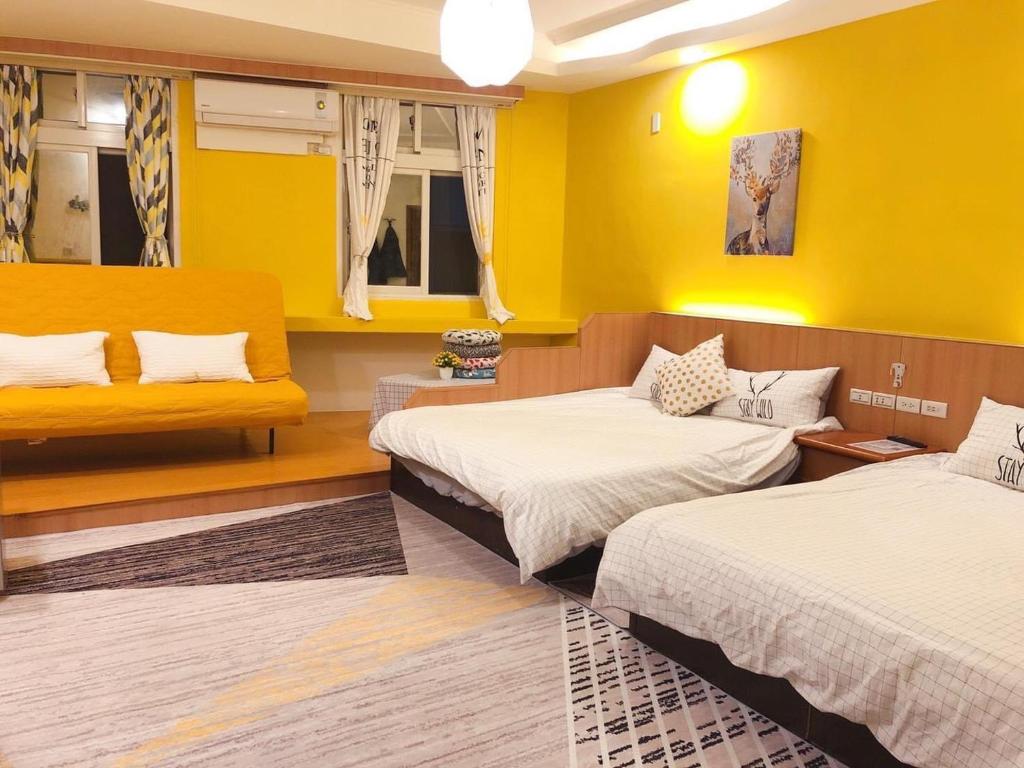 馬公市的住宿－風沙月民宿，黄色墙壁客房的两张床