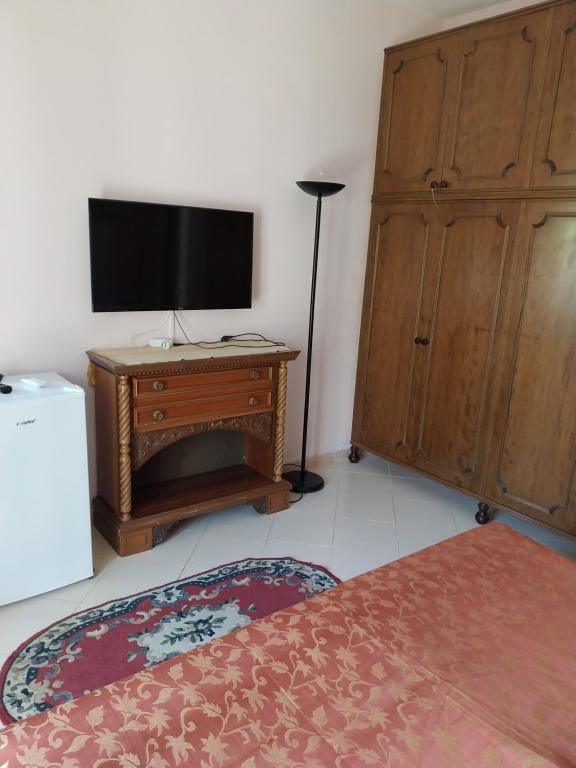 1 dormitorio con 1 cama, TV y vestidor en Casa Bianca, en Sant'Egidio del Monte Albino