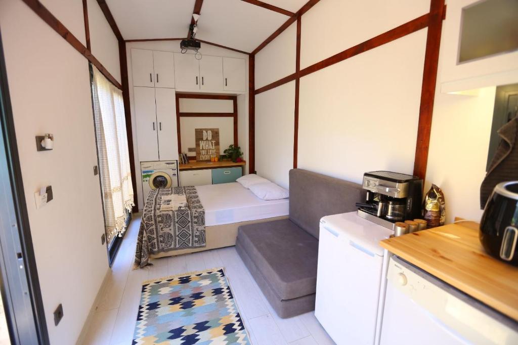 um pequeno quarto com uma cama e uma cozinha em Athena Tiny House em Bodrum City