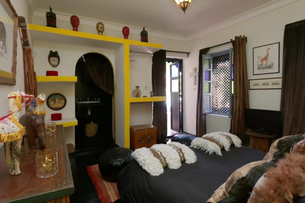 una sala de estar con una cama con almohadas. en Dar Didifa en Marrakech
