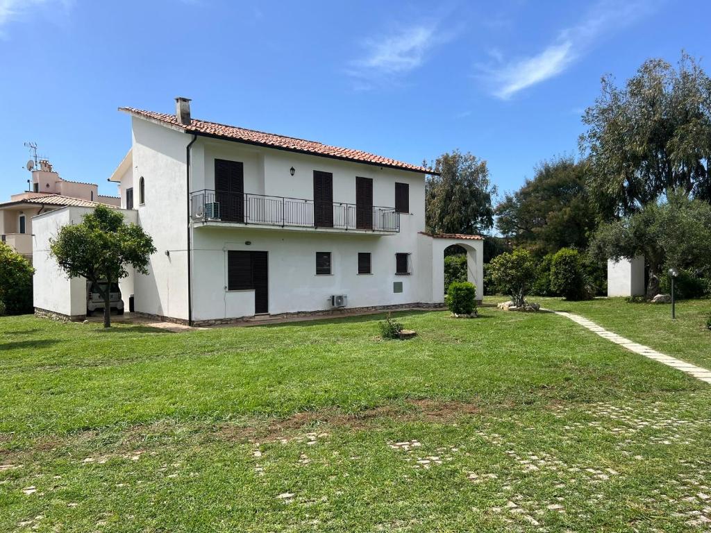 a large white house with a green yard at Sperlonga Apartment in Sperlonga
