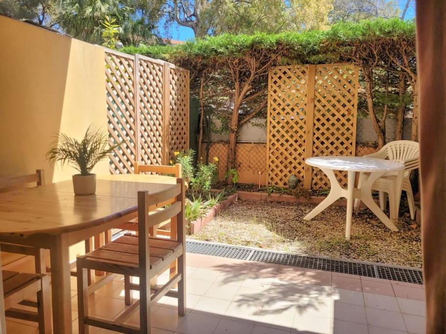 un patio avec une table et des chaises et une clôture dans l'établissement Appartement 5 couchages + jardin à 150m des plages, à Saint-Raphaël