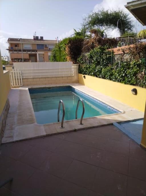 - une petite piscine avec 2 bars en métal dans l'établissement Casa adosada en Daimus solo para familias, à Daimús