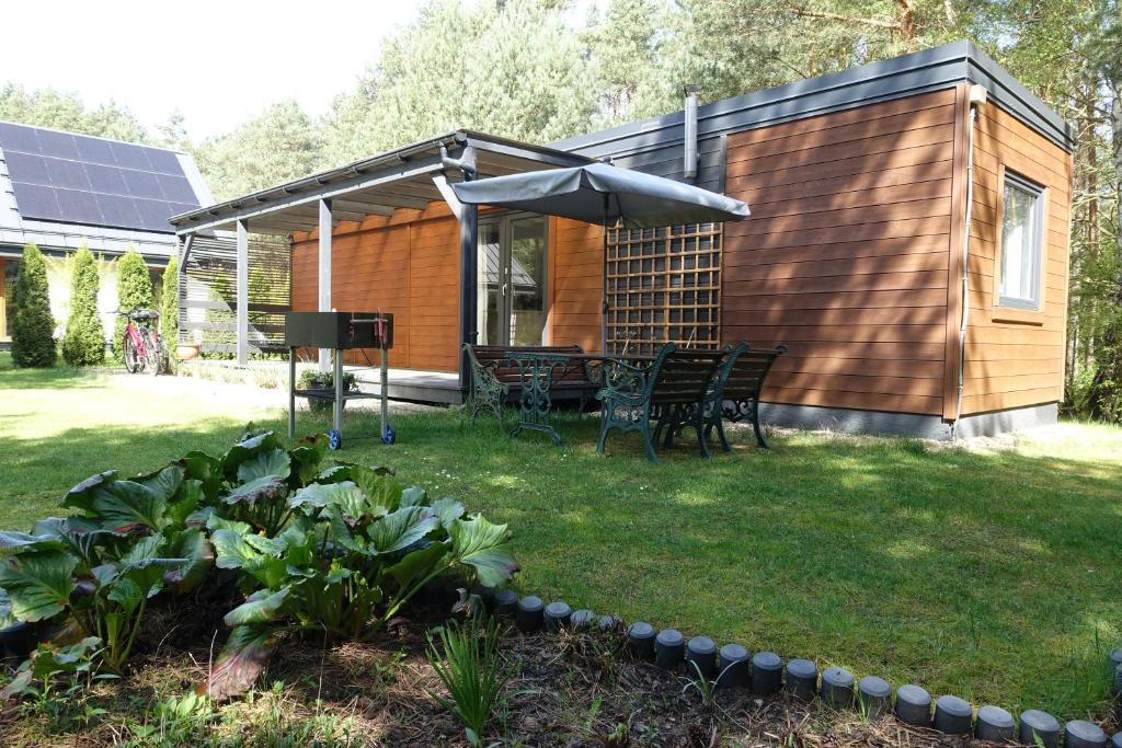 a backyard with a house with an umbrella at Domek nad Wartą - Park krajobrazowy in Konopnica