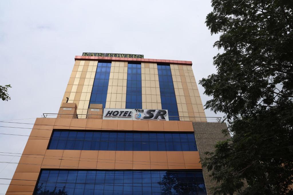 a building with a sign on the top of it at HOTEL SR in Palani