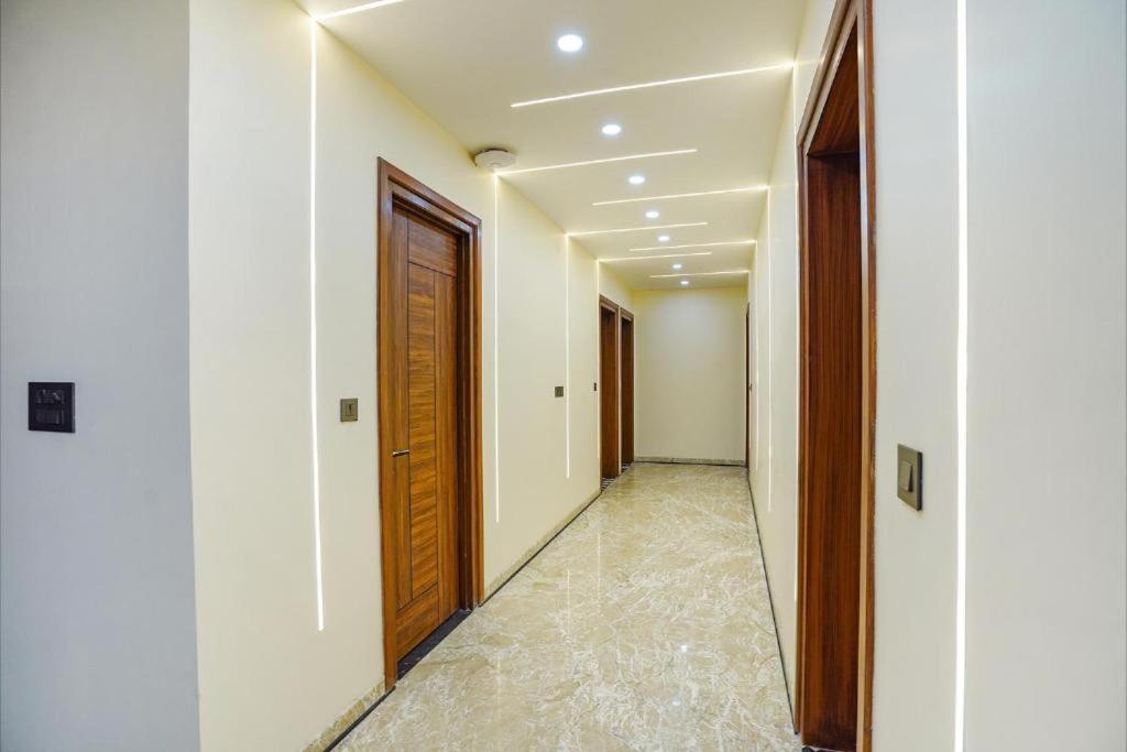 a hallway with wooden doors and a tile floor at The Grand Mansion Hotel in Greater Noida