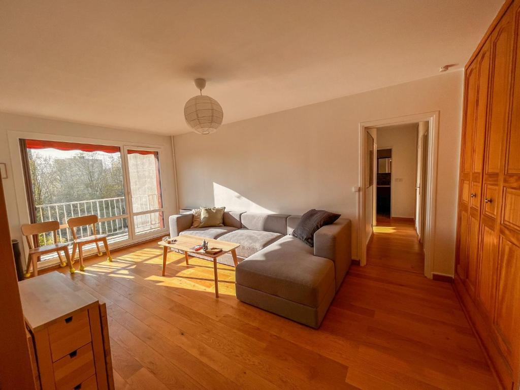 een woonkamer met een bank en een tafel bij Appartement tout confort avec vue in Saint-Denis