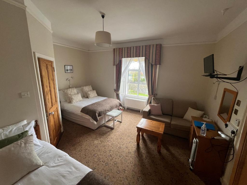 um quarto de hotel com uma cama e um sofá em Ashmore House em Cashel