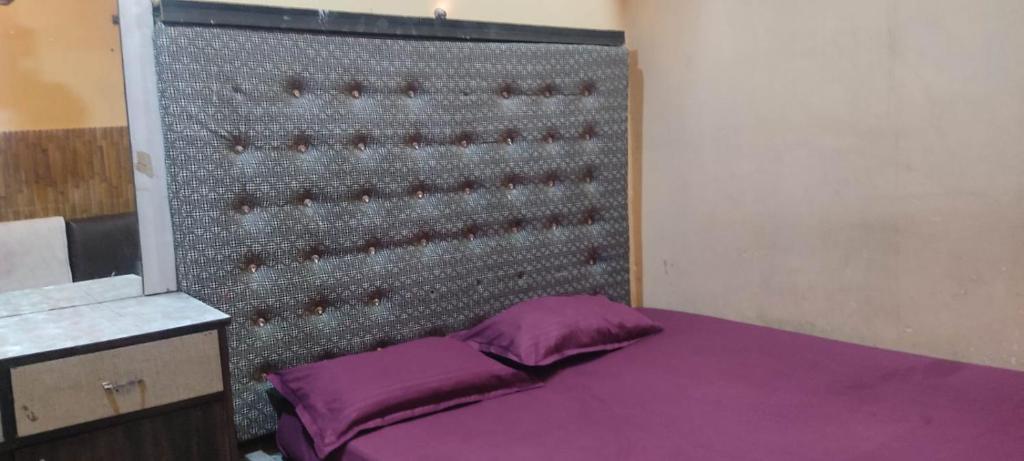 een slaapkamer met een paars bed en een metalen muur bij Rajs Lodging & Fooding (Guest House) in Calcutta