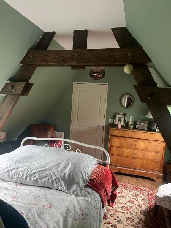 1 dormitorio con cama y pared verde en Chambre cosy, 