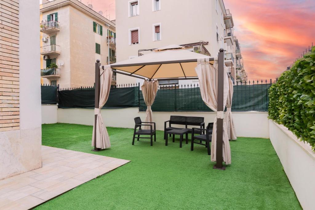 a patio with a table and chairs on green grass at Luciano Secret Garden Apartment in Rome