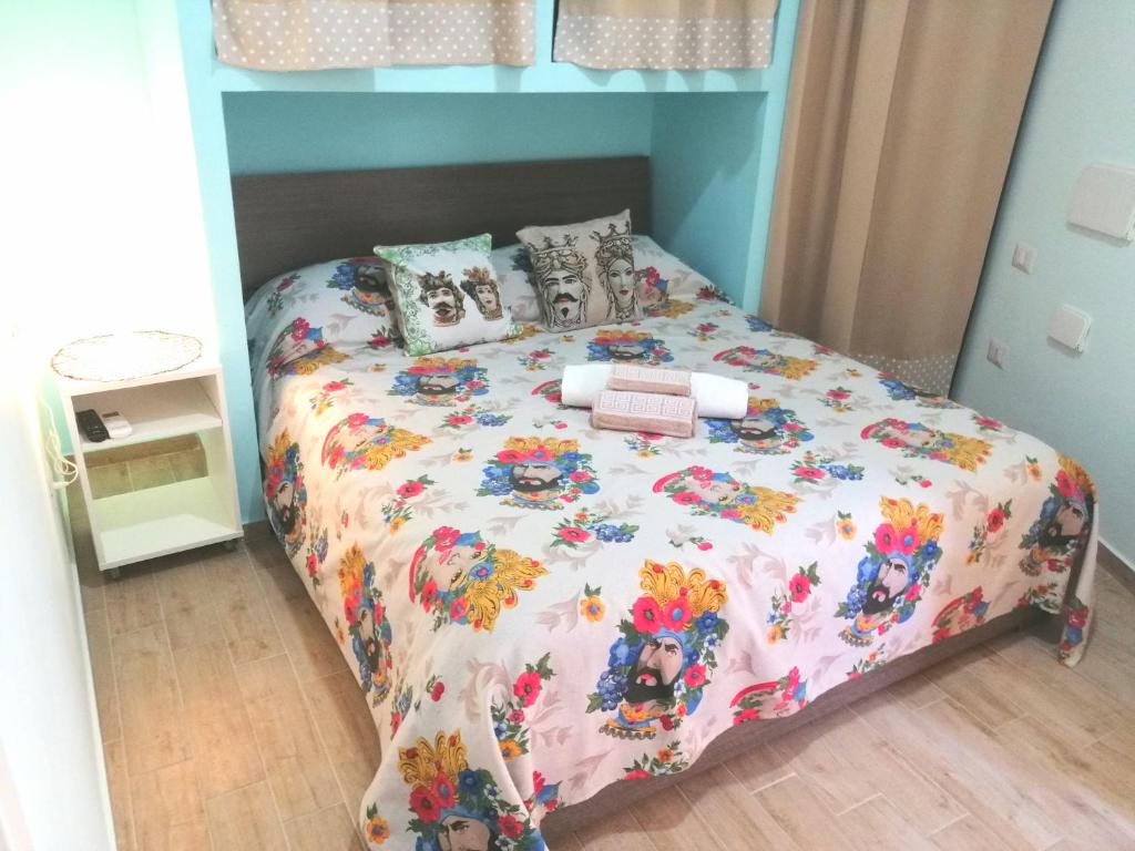 a bedroom with a bed with a floral bedspread at I mori di Sicilia in Giardini Naxos