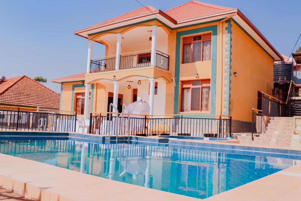 un homme debout en face d'une maison avec piscine dans l'établissement SUNFLOWER HOMEs VILLA, à Kigali