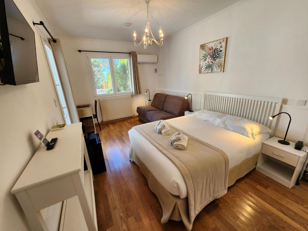 a bedroom with a large bed and a couch at Hôtel de Charme Brise Marine in Saint-Jean-Cap-Ferrat